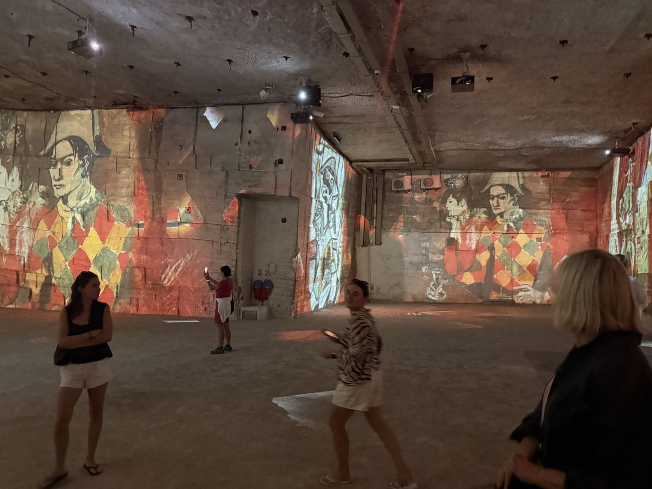 The girls silhouetted in the projections at Carrières des Lumières