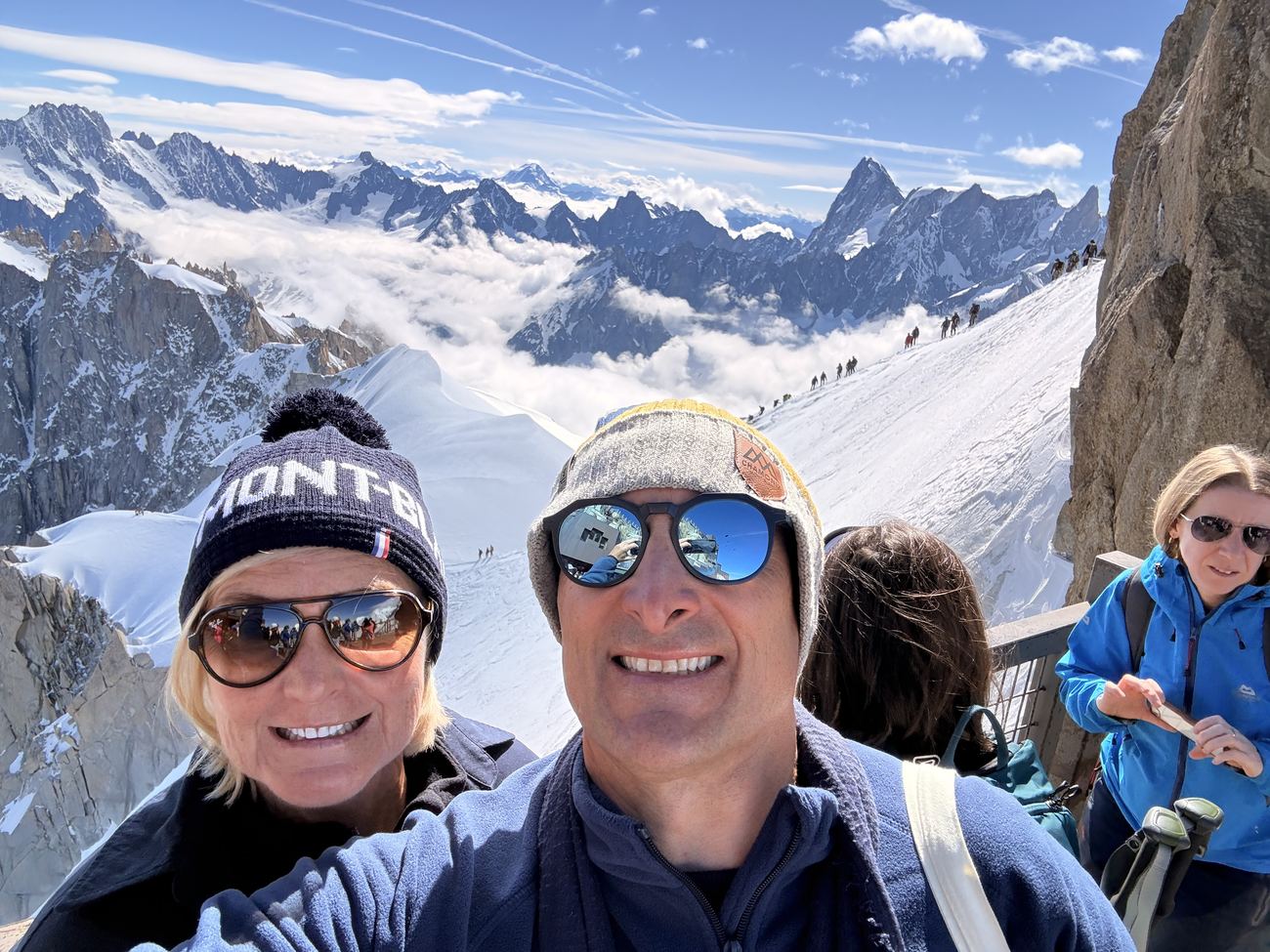 Near the top, climbers on the arête behind